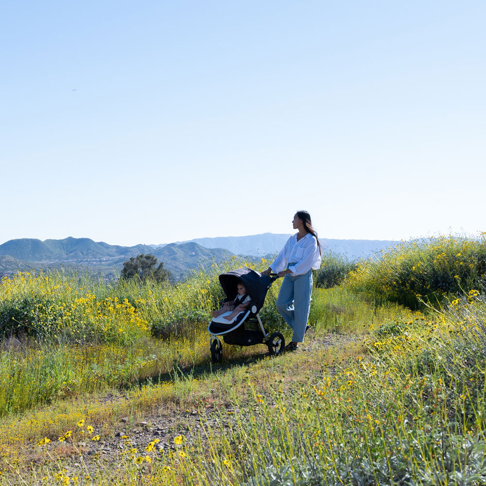 Mom goes on a hike while pushing baby in Bumbleride 2024 Indie All Terrain Stroller - Dusk