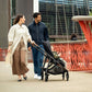 Woman and man go sightseeing while pushing child in Nuna SWIV Stroller - Caviar