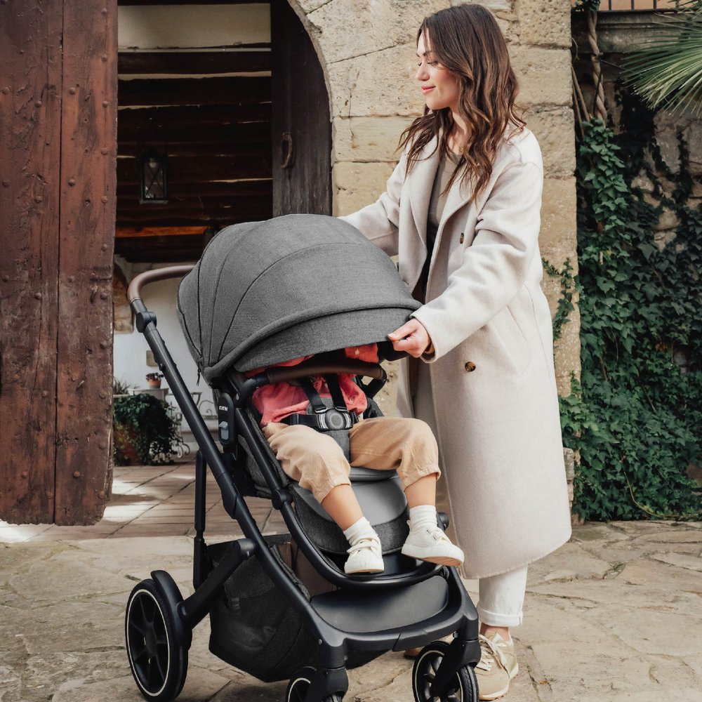 Mom extends canopy over child in Romer Tura Stroller - Peppercorn