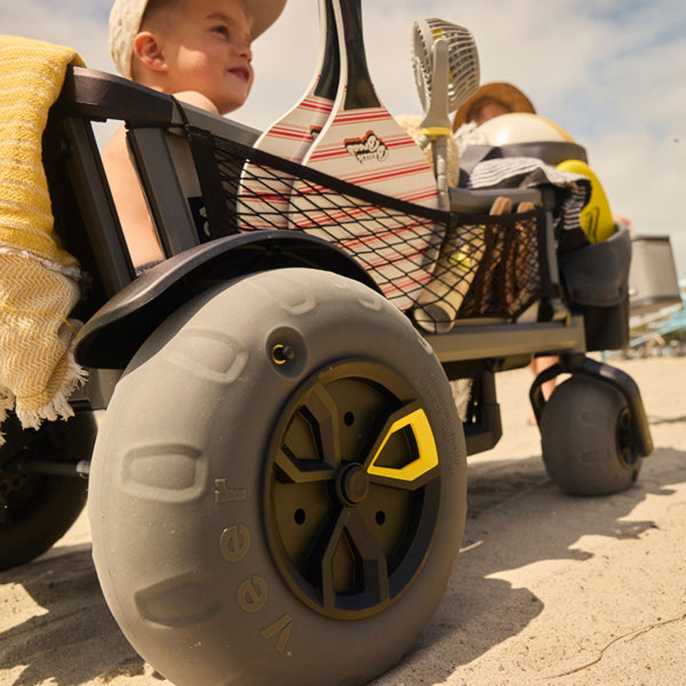 Little boy rides in Cruiser with attached Veer Beach Wheel Kit - Set of 4