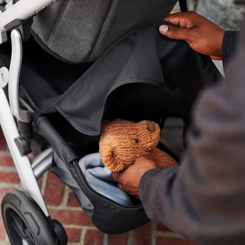 Dad places teddy bear into UPPAbaby Basket Cover - VISTA / CRUZ