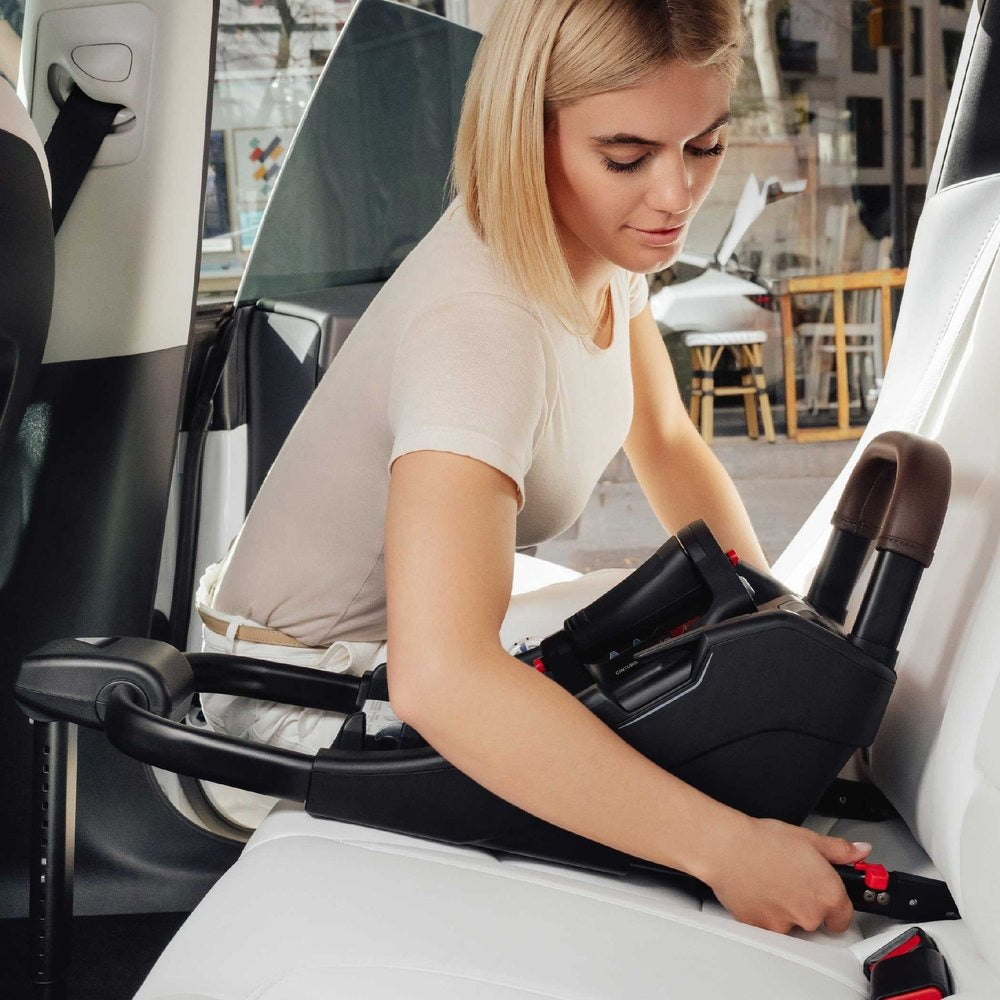 Woman installing Romer Versa Infant Car Seat Base into vehicle