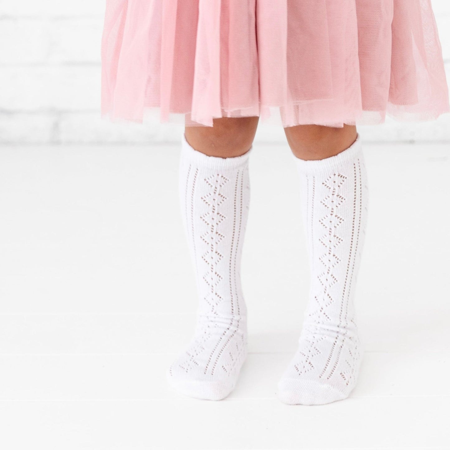 Little girl wearing Little Stocking Co Scalloped Fancy Knee High Socks - White