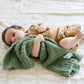 Baby holds Saranoni Mini Bamboni Blanket - Olive